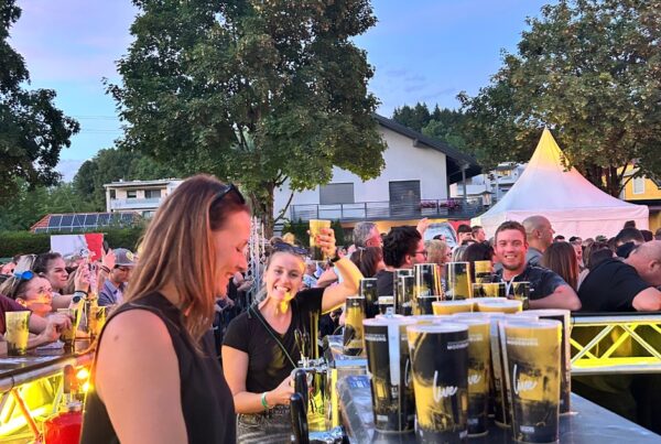 Zwei Frauen hinter einer Bartheke bei einem Konzert abends mit Publikum im Hintergrund