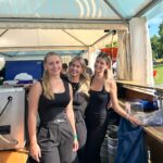 Drei Frauen hinter einer Bartheke bei einem Konzert tagsüber