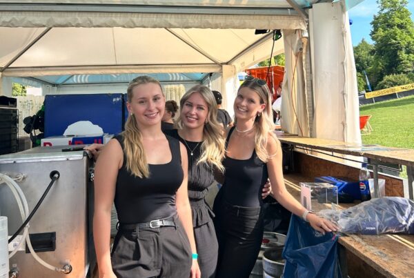 Drei Frauen hinter einer Bartheke bei einem Konzert tagsüber
