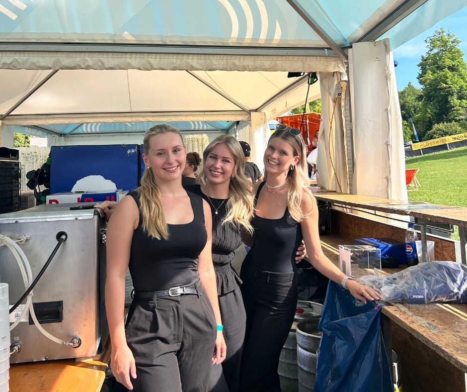 Drei Frauen hinter einer Bartheke bei einem Konzert tagsüber