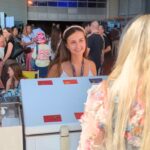 Hostess an Eisausgabestand mit Kundin im Gespräch