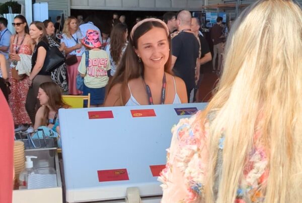 Hostess an Eisausgabestand mit Kundin im Gespräch