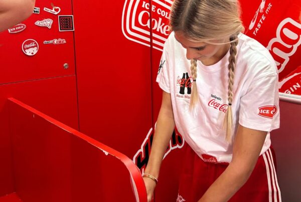 blonde Hostess hinter dem roten Coca Cola Tresen