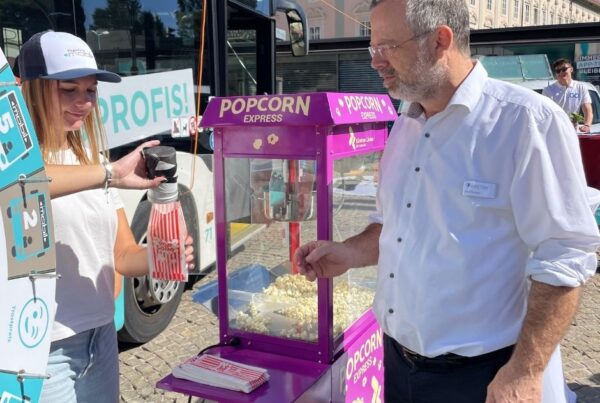 Frau füllt Popcorn in Tüte für einen wartenden Gast