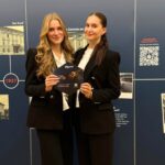 zwei weibliche Hostessen vor Werbewand