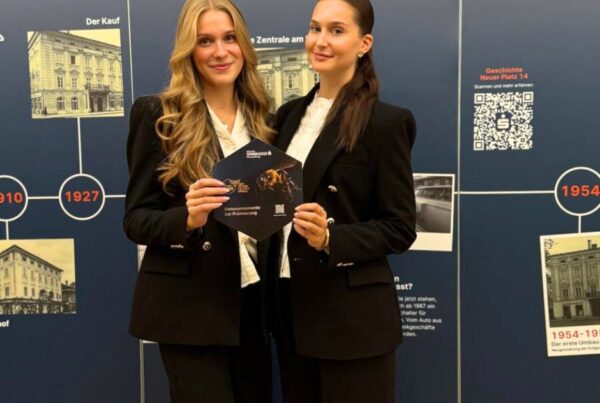 zwei weibliche Hostessen vor Werbewand