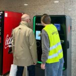 Frau erklärt am Parkautomaten neues Parkleitsystem einem Herrn