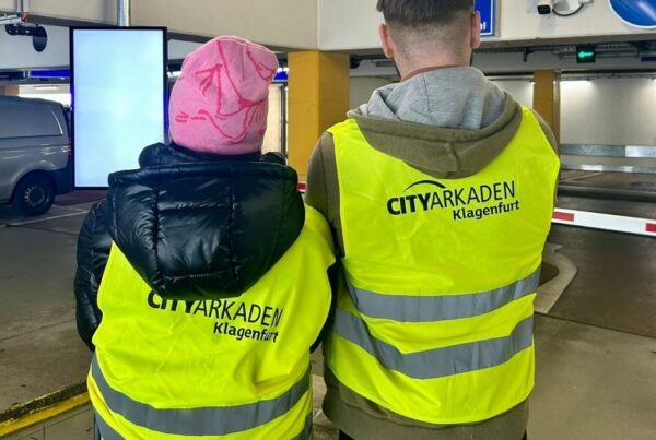 zwei Personen mit Warnwesten mit City Arkaden Aufschrift von hinten