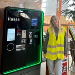 Frau neben Parkscheinautomat