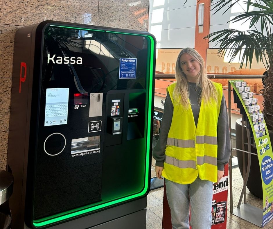Frau neben Parkscheinautomat