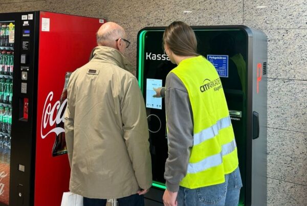 Frau erklärt am Parkautomaten neues Parkleitsystem einem Herrn