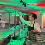 Kellner holt Glas aus dem Regal