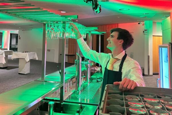 Kellner holt Glas aus dem Regal