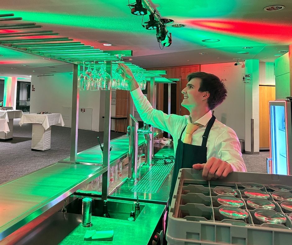 Kellner holt Glas aus dem Regal