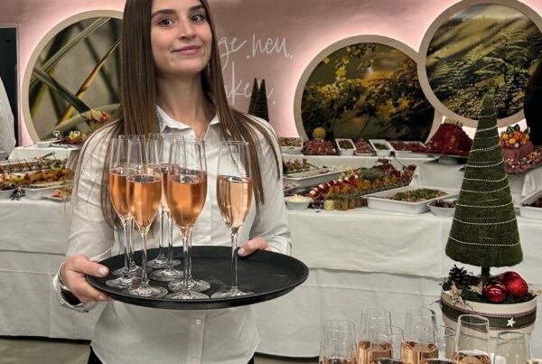 Frau trägt Tablett mit Sektgläsern